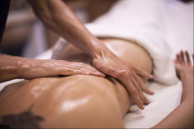 Eine Person erhält eine Massage, die Hände wirken entspannend auf den Rücken.